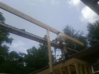 Carpenter setting a ridge beam over a new addition frame — Ice Dam Removal by Roofing Brothers in West Manchester