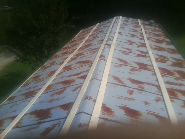 Rusted metal roof panels with new wood purlins before replacement — Storm Damage Roof Repair in West Manchester by Roofing Brothers