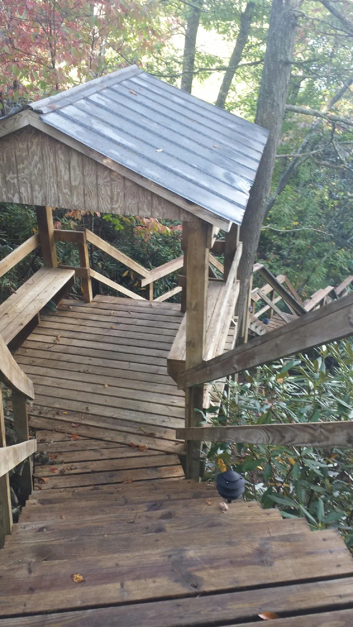 Metal roofed shelter over wooden steps on a wooded walkway — Skylight Repair & Installation work by our crew in West Manchester