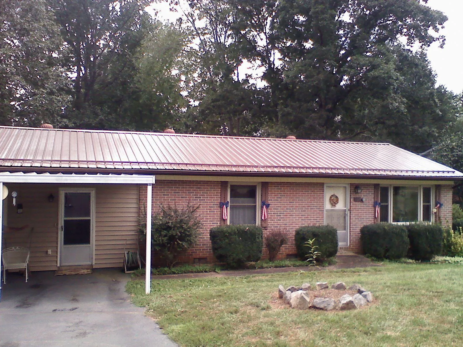 Bronze metal roof and carport on a brick ranch home — Roof Repair work by our crew in West Manchester